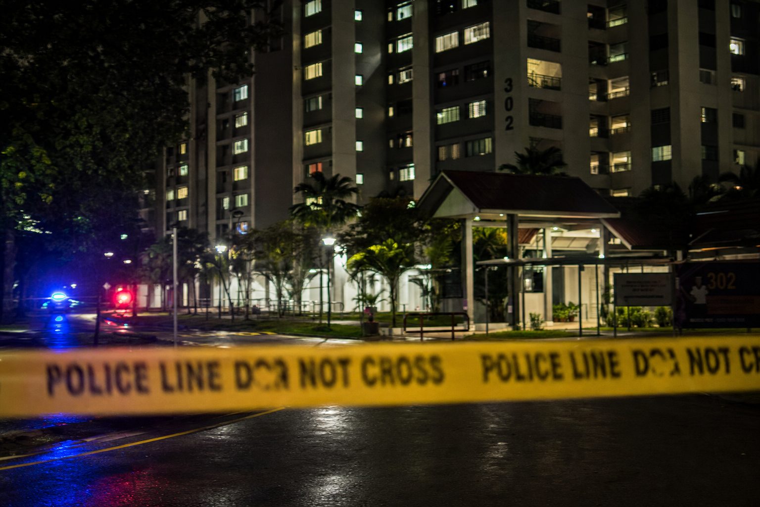 Cordoned street outside a residential block in central Singapore, night scene